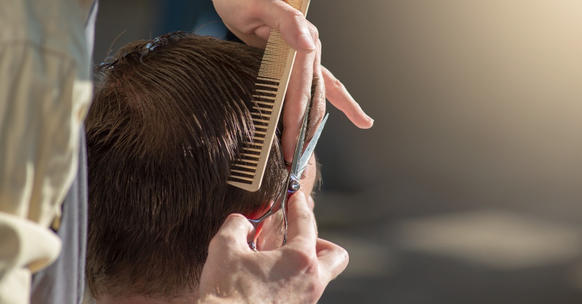 Manos de un primer plano de peluquería de tijeras y un peine. el peluquero está cortando a un hombre y haciéndole un corte de pelo. foto horizontal con lugar de texto